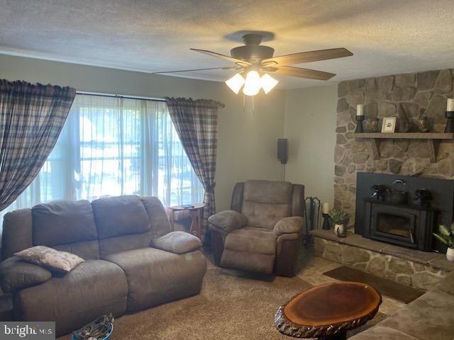 living area featuring carpet floors, a ceiling fan, and a textured ceiling
