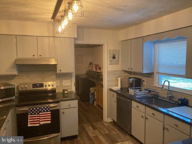 kitchen featuring a sink, stainless steel appliances, a textured ceiling, and under cabinet range hood