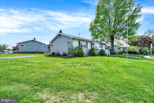 ranch-style house with a chimney, central AC, and a front lawn