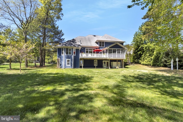 back of house featuring a lawn, a deck, and a sunroom