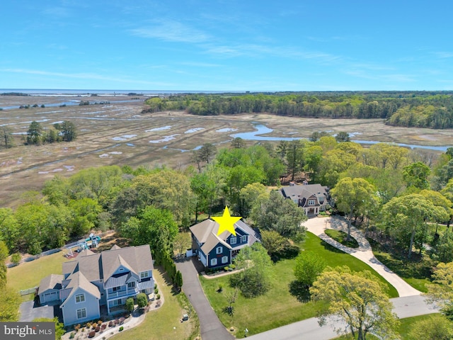 drone / aerial view featuring a water view and a wooded view
