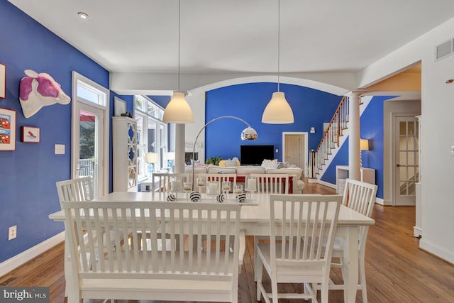 dining area featuring stairway, baseboards, wood finished floors, and visible vents