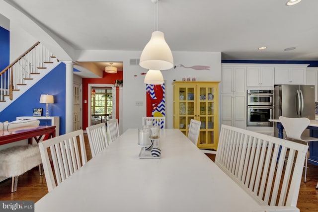 dining space featuring recessed lighting, wood finished floors, and stairway