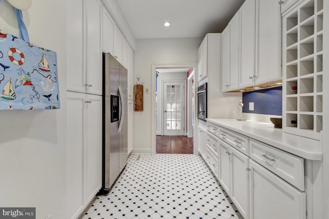 kitchen with light countertops, light tile patterned floors, white cabinets, stainless steel appliances, and recessed lighting
