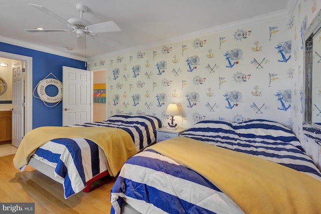bedroom featuring crown molding, wallpapered walls, wood finished floors, and connected bathroom