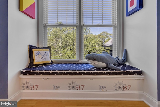sitting room with a healthy amount of sunlight, baseboards, and wood finished floors