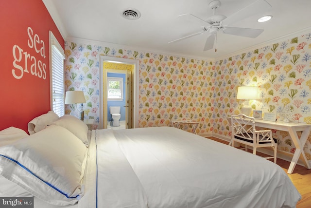 bedroom with ornamental molding, wallpapered walls, and wood finished floors