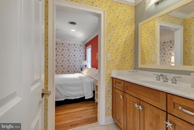 bathroom featuring crown molding, vanity, visible vents, wallpapered walls, and ensuite bath