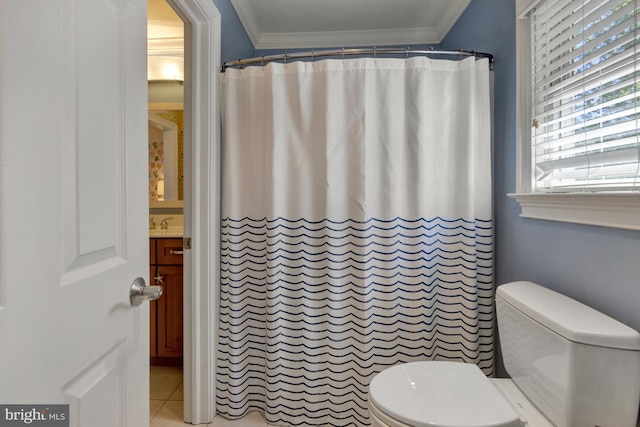 bathroom featuring crown molding, plenty of natural light, tile patterned flooring, and toilet