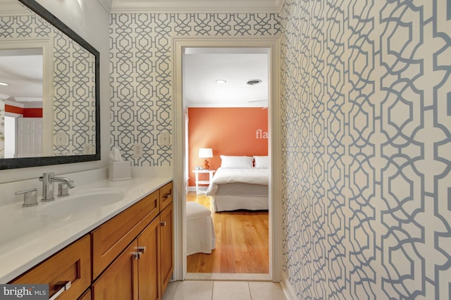 ensuite bathroom featuring crown molding, wallpapered walls, and connected bathroom