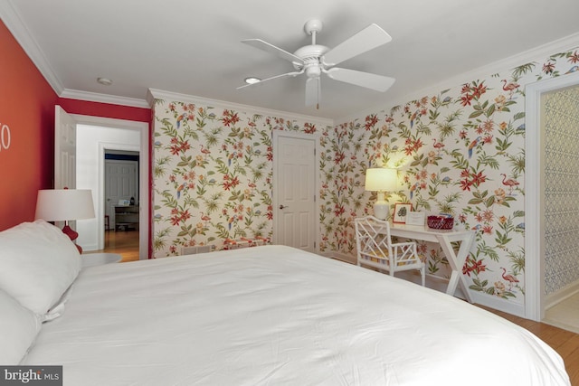 bedroom featuring crown molding, wood finished floors, baseboards, ceiling fan, and wallpapered walls