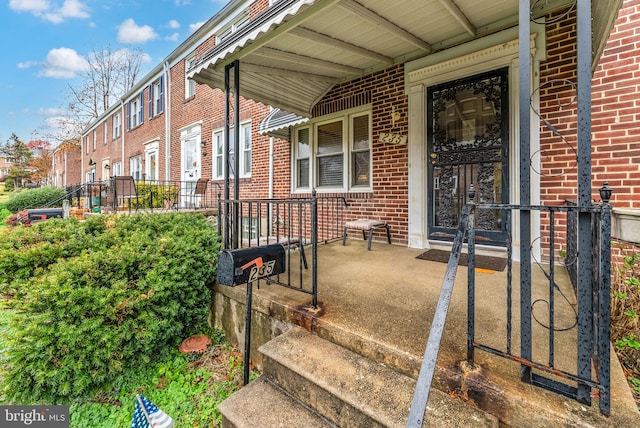 235 Medwick Garth E, Baltimore, MD 21228 - doorway to property with a porch and brick siding