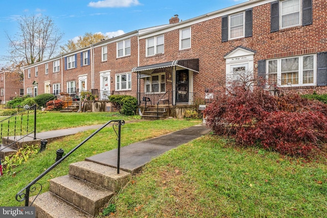 235 Medwick Garth E, Baltimore, MD 21228 - view of front of house with brick siding, a chimney, a front yard, and a residential view
