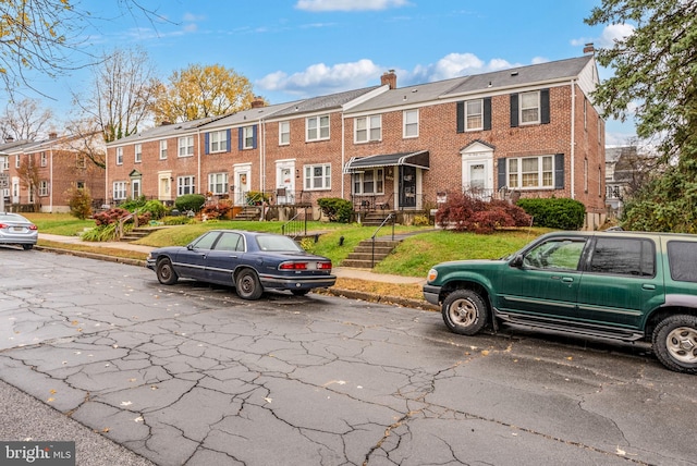 235 Medwick Garth E, Baltimore, MD 21228 - view of front of house featuring brick siding, a front lawn, a chimney, and a residential view