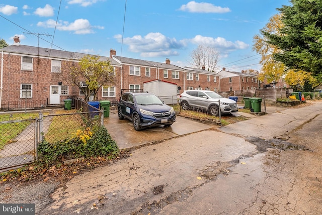 235 Medwick Garth E, Baltimore, MD 21228 - view of front facade with fence, brick siding, and a residential view
