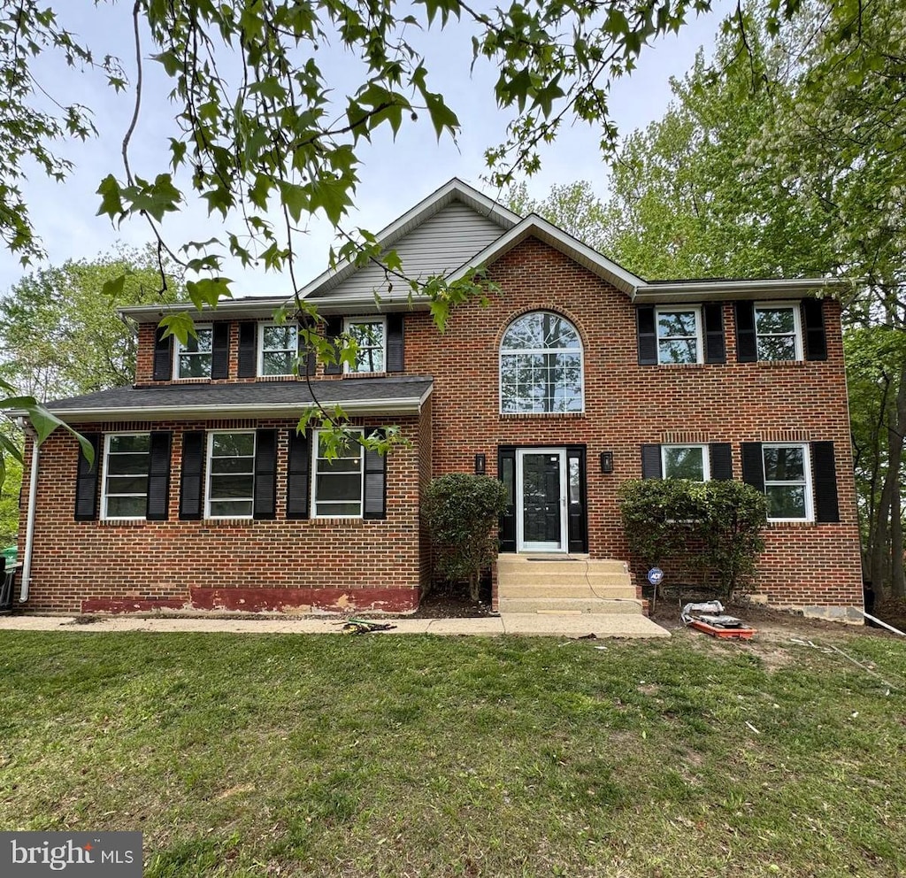 view of front of house with brick siding and a front yard