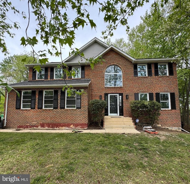 view of front of house with brick siding and a front yard