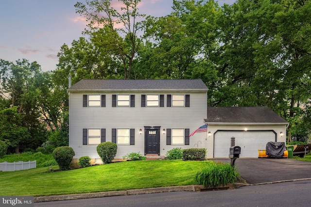 1604 Kathryn St, New Cumberland, PA 17070 - colonial-style house with asphalt driveway, a front lawn, a garage, and view of scattered trees