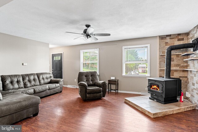 1604 Kathryn St, New Cumberland, PA 17070 - living area featuring a wood stove, wood finished floors, baseboards, and a ceiling fan
