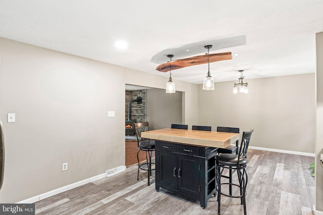 1604 Kathryn St, New Cumberland, PA 17070 - dining room with a wood stove, light wood finished floors, and baseboards