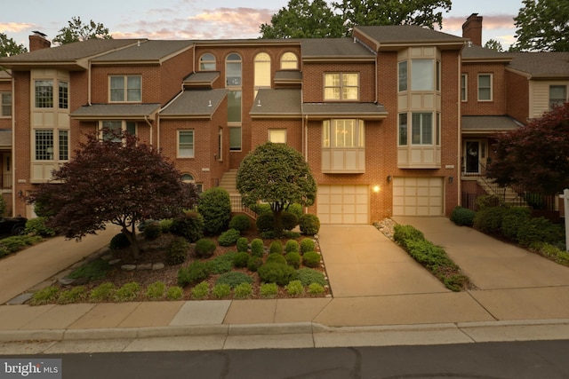 10204 Aspen Willow Dr, Fairfax, VA 22032 - townhome / multi-family property with driveway, an attached garage, brick siding, and a chimney