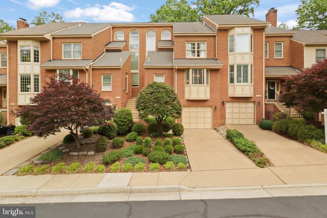 10204 Aspen Willow Dr, Fairfax, VA 22032 - view of property featuring driveway, a garage, brick siding, and a chimney
