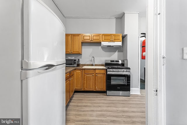 840 Cumberland St, Gloucester City, NJ 08030 - kitchen featuring stainless steel appliances, under cabinet range hood, a sink, light wood-style flooring, and brown cabinetry