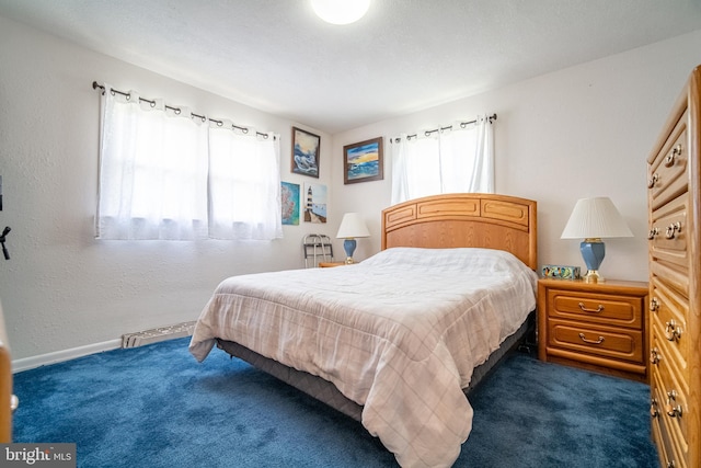 bedroom with dark colored carpet and baseboards
