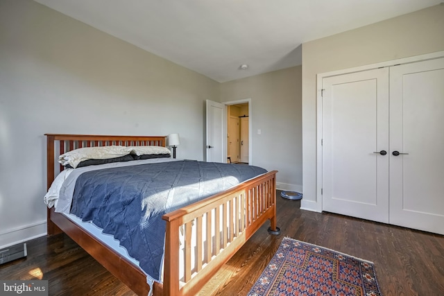 bedroom featuring baseboards, wood finished floors, and a closet