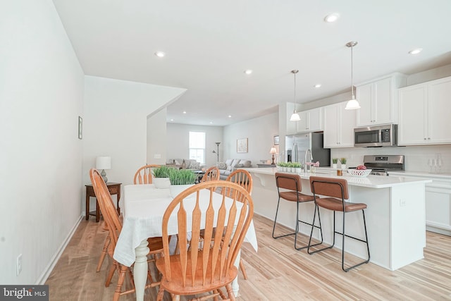 dining area with recessed lighting and light wood finished floors