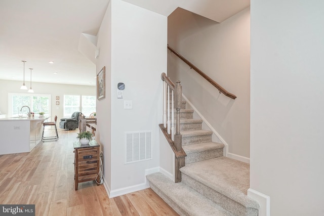 stairs featuring recessed lighting, baseboards, visible vents, and wood finished floors