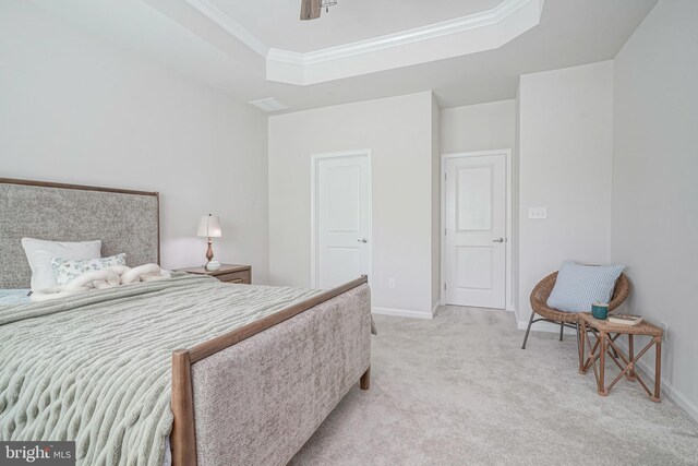bedroom with a raised ceiling, baseboards, and light colored carpet