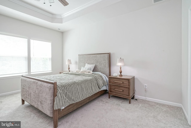 carpeted bedroom with crown molding, baseboards, ceiling fan, and a raised ceiling