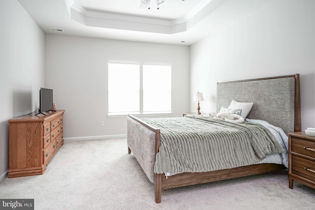 bedroom featuring light carpet, a raised ceiling, baseboards, visible vents, and ornamental molding