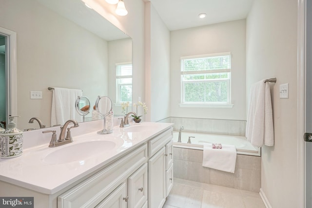bathroom featuring a sink, a bath, and a wealth of natural light