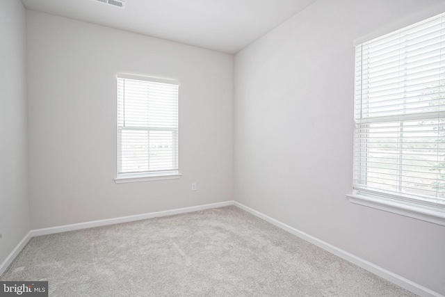 empty room featuring baseboards and carpet