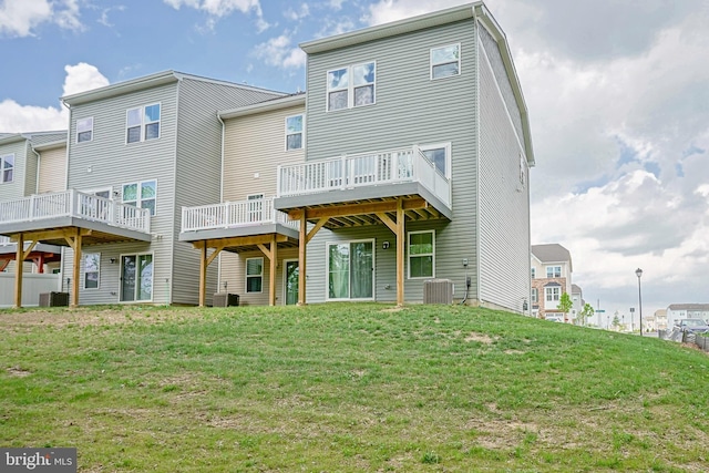 back of property featuring central AC unit, a wooden deck, and a yard