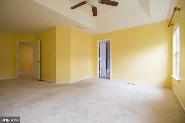empty room with baseboards, visible vents, light carpet, and a ceiling fan
