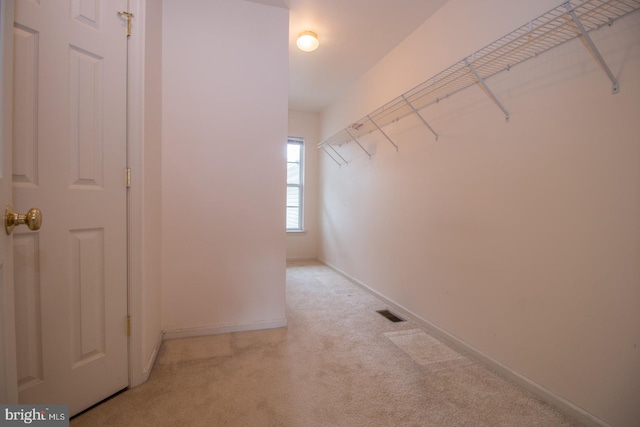 spacious closet featuring light colored carpet and visible vents