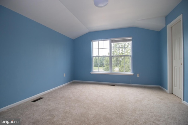 additional living space featuring visible vents, vaulted ceiling, carpet, and baseboards