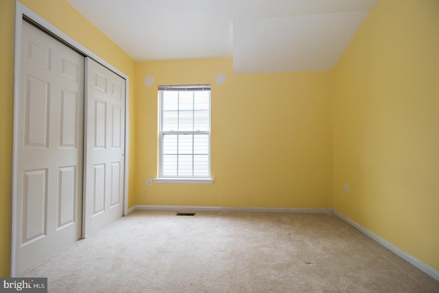 unfurnished bedroom with baseboards, visible vents, a closet, and carpet