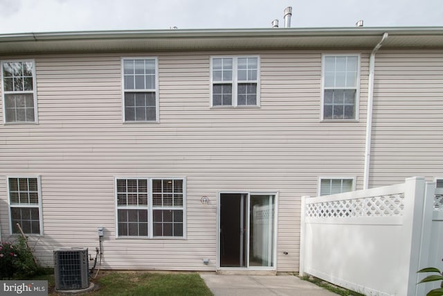 rear view of property featuring cooling unit, a patio, and fence