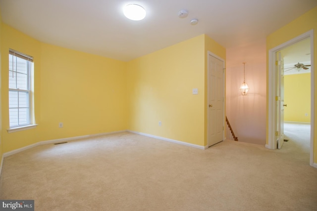 unfurnished room featuring baseboards, visible vents, and carpet flooring