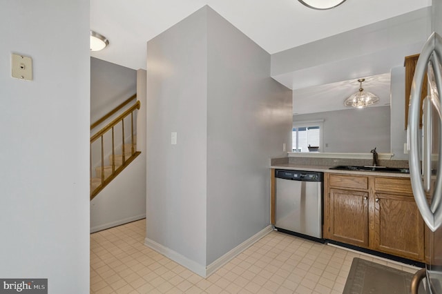 46726 Summit Ter Unit 136, Sterling, VA 20164 - kitchen with baseboards, brown cabinets, a sink, appliances with stainless steel finishes, and decorative light fixtures