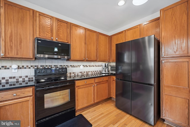14019 Rockingham Rd, Germantown, MD 20874 - kitchen with stainless steel appliances, dark countertops, light wood-type flooring, brown cabinetry, and backsplash