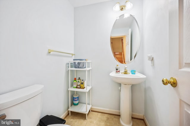 14019 Rockingham Rd, Germantown, MD 20874 - bathroom featuring toilet, baseboards, and a sink