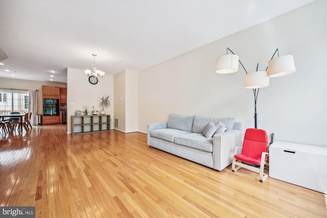 14019 Rockingham Rd, Germantown, MD 20874 - living room with light wood-style flooring and a chandelier