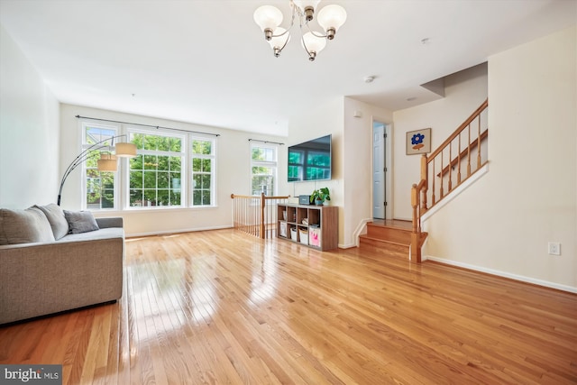 14019 Rockingham Rd, Germantown, MD 20874 - living room with light wood-style floors, a chandelier, baseboards, and stairway