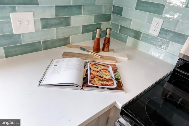 details with tasteful backsplash and range with electric stovetop