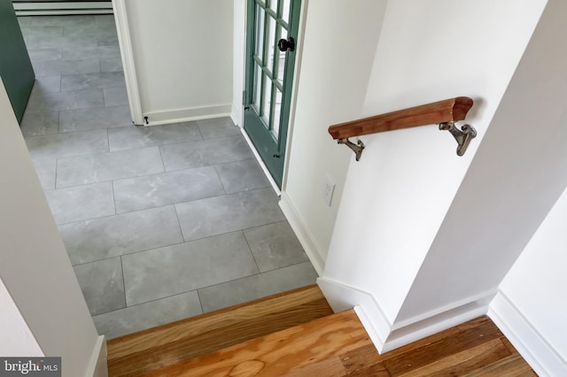 staircase with baseboards and tile patterned floors
